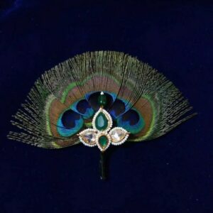 Premium Morpankh Shringar for Laddu Gopal Ji This Premium Green Stone Morpankh Shringar is a finely handcrafted devotional accessory inspired by the divine symbolism of Lord Krishna’s beloved peacock feather. Designed with a natural morpankh spread, the centerpiece is adorned with elegant green stones and delicate pearl borders that reflect purity, devotion, and grace. The deep green and blue hues of the feather represent spiritual calm and divine beauty, making this shringar piece perfect for elevating Laddu Gopal Ji’s appearance during daily seva as well as special occasions.